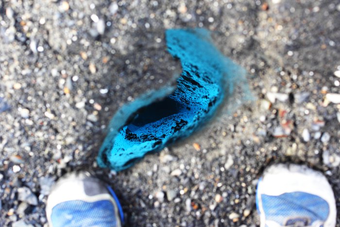 Between my feet this melt pit cuts deep into the blue ice.